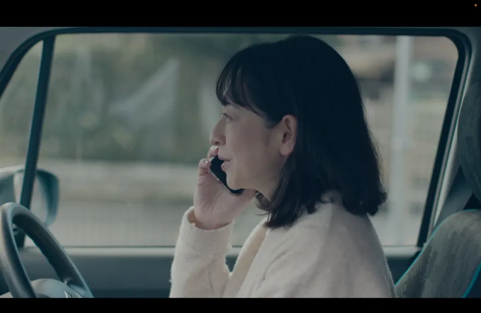 車内で通話する洋子