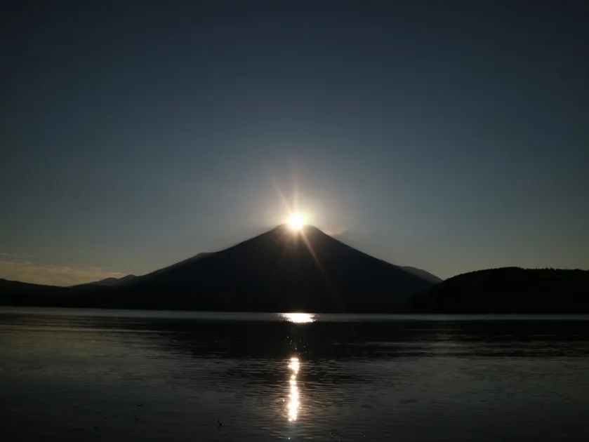 湖面に日の光が反射する富士山