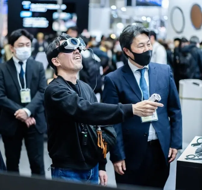 VR/ARヘッドセットを装着し、コントローラーを操作しながら笑顔で上を見上げる男性