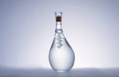 透明な液体と白いジグザグの飾りが入れられた、雫型のガラスボトル