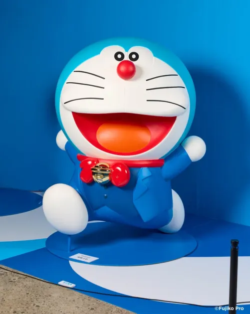 青い背景に立つドラえもんの像