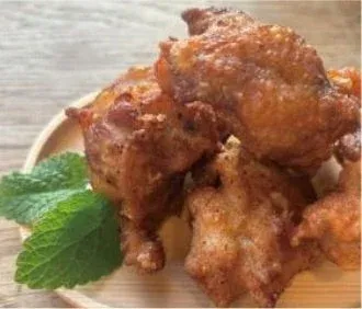 木製の皿に盛られた、きつね色に揚がったジューシーな唐揚げ