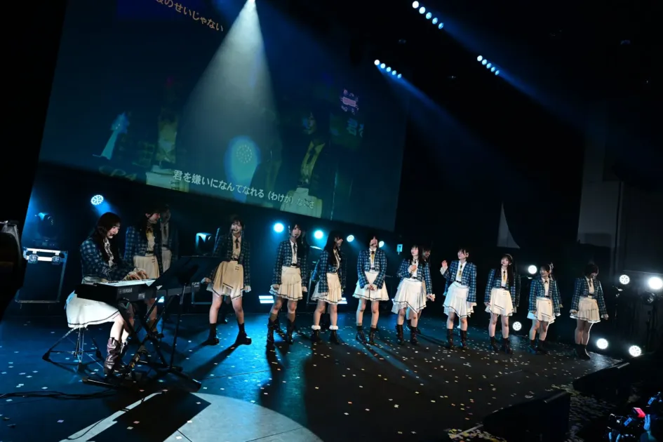 キーボードを演奏するメンバーと歌い踊るアイドルグループ