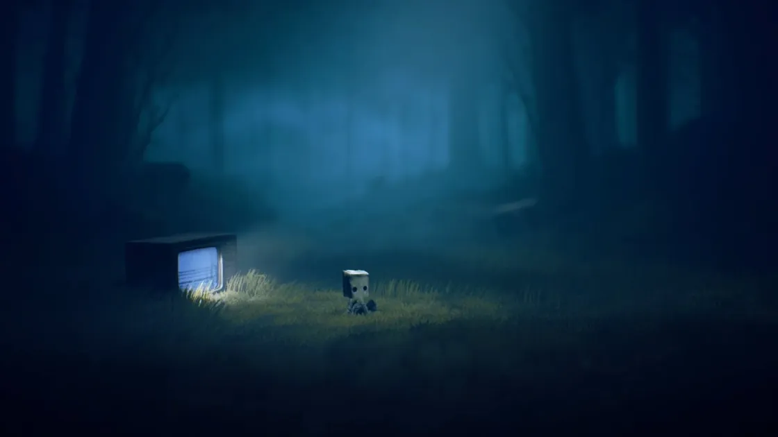 暗く霧がかった森の中、顔に紙袋を被った小さなキャラクターが光る古いテレビのそばに座っている
