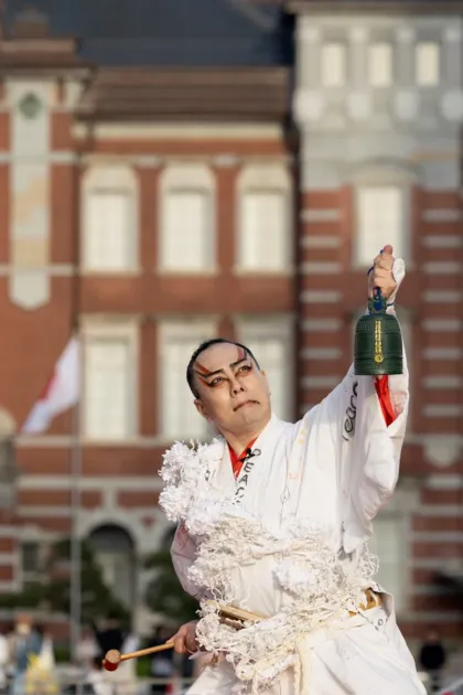 隈取メイクと和服姿の男性が屋外でパフォーマンス中。