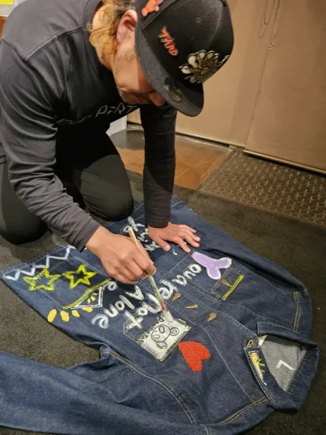 デニムジャケットにペイントを施すアーティスト