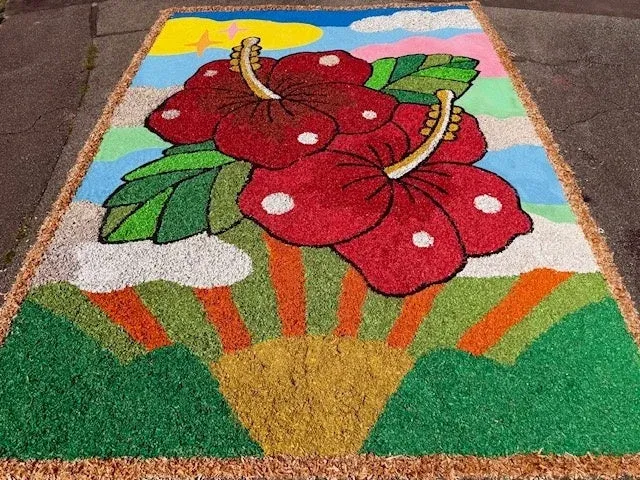 地面に描かれた鮮やかなハイビスカスと夏の風景のアート作品。