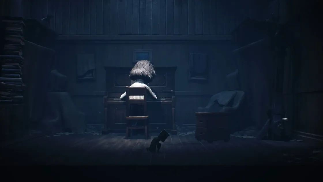 暗い部屋で、小さな少女がピアノを弾いている後ろ姿