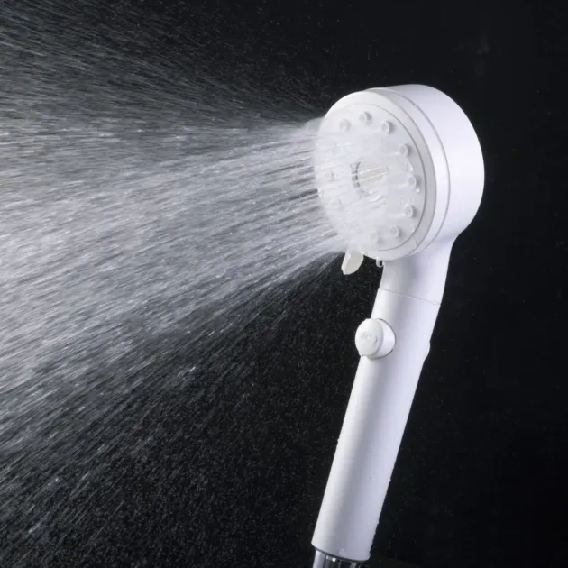 白いシャワーヘッドから勢いよく水が噴射されている様子