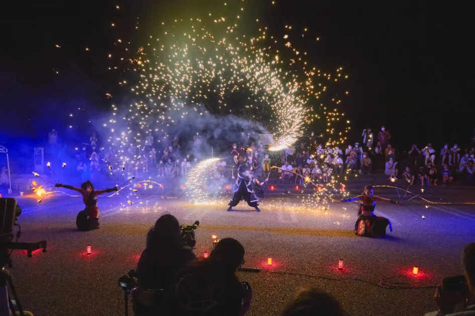 夜空の下、火花や炎を操るファイヤーパフォーマンス