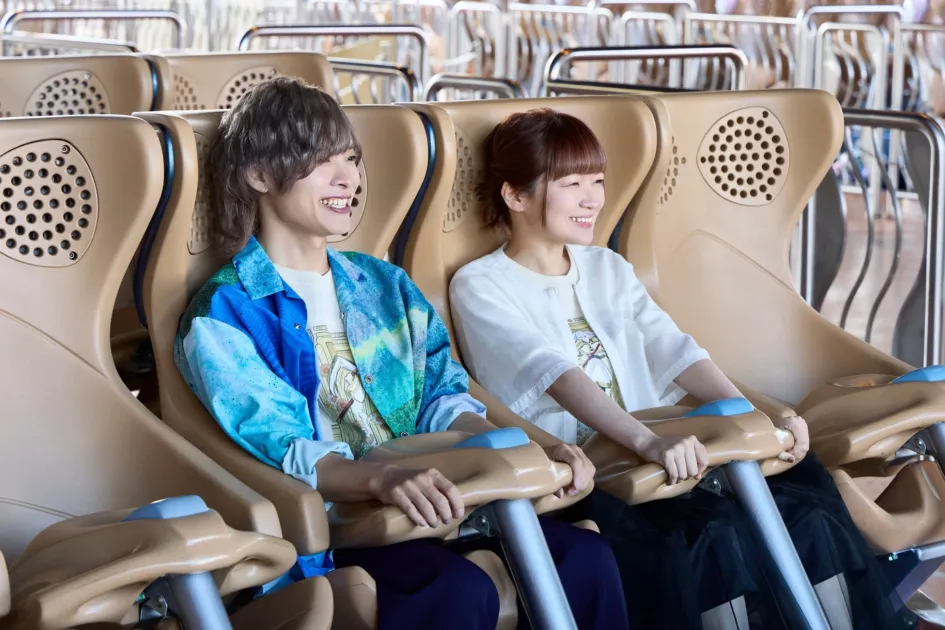 テーマパークのアトラクションに乗る若い男女