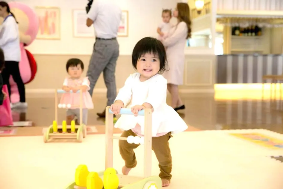 歩行器を押して歩く赤ちゃん