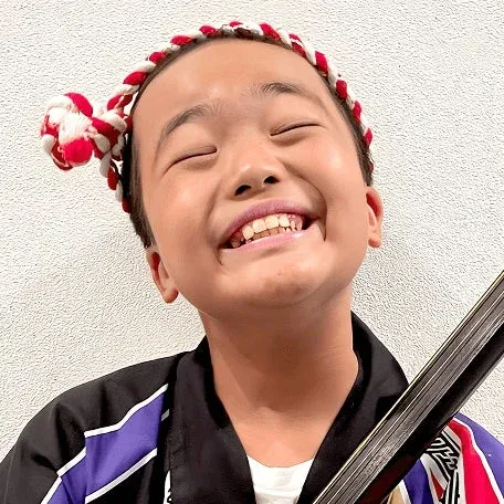 笑顔で三味線を持つ少年