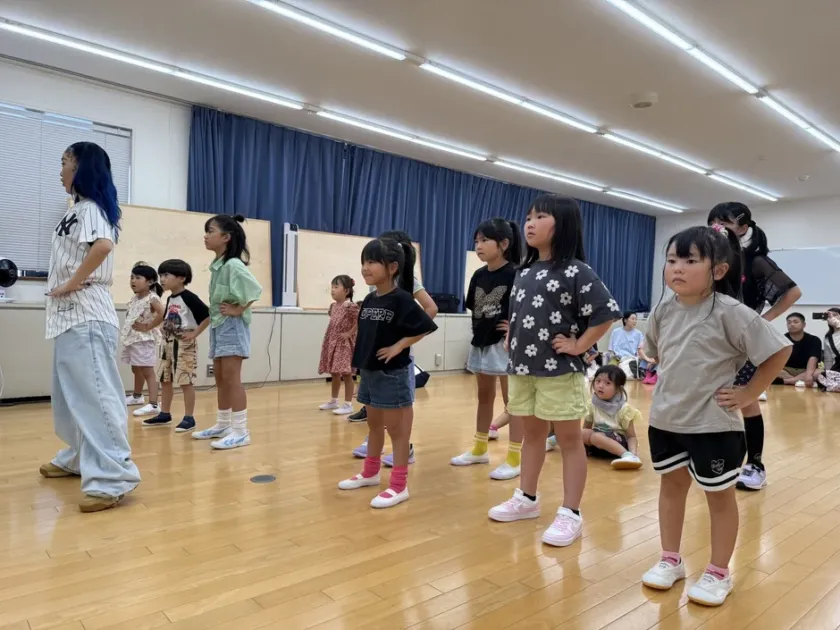 ダンススタジオで子供たちにポーズを指導するインストラクター