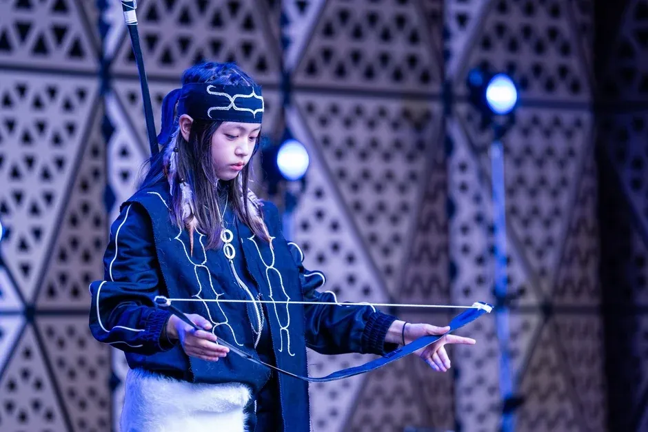 ステージ上でムックリを演奏する少女