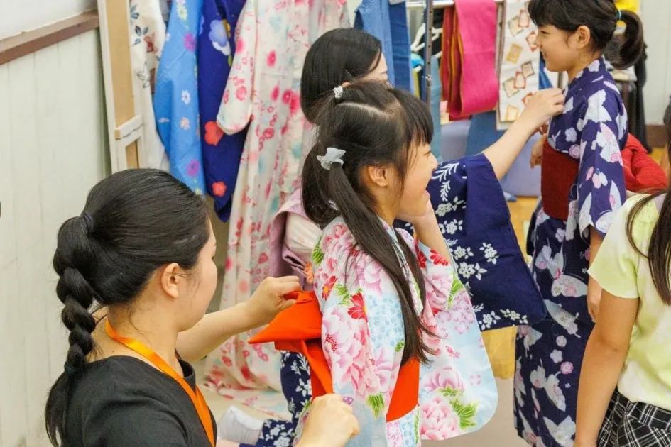 浴衣の着付けをする女の子たち