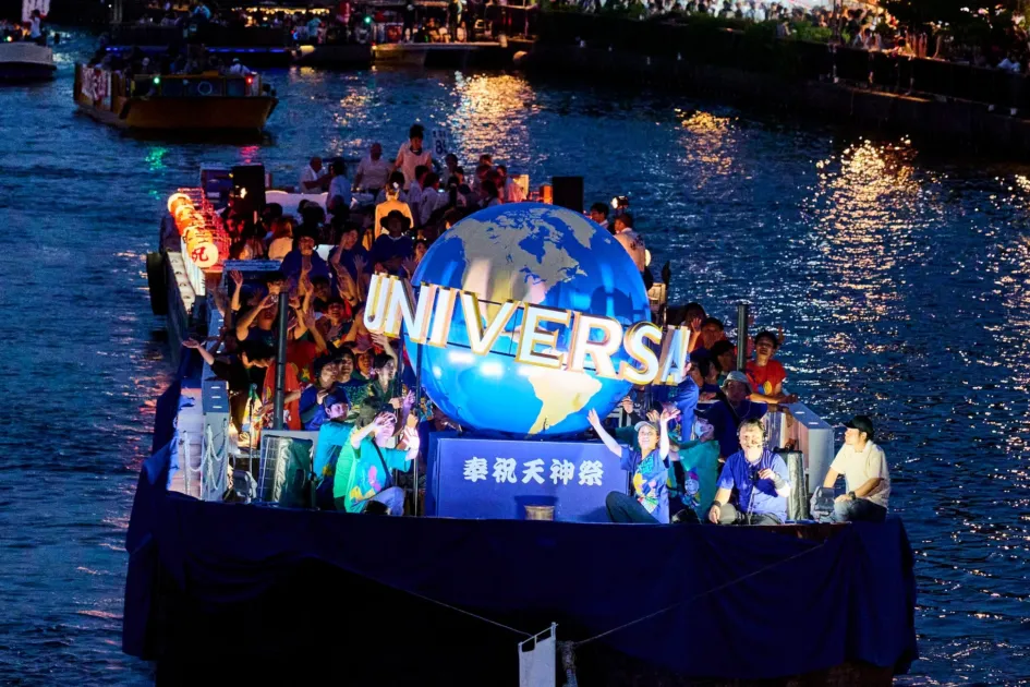 夜の天神祭で輝くUSJの地球儀を載せた船