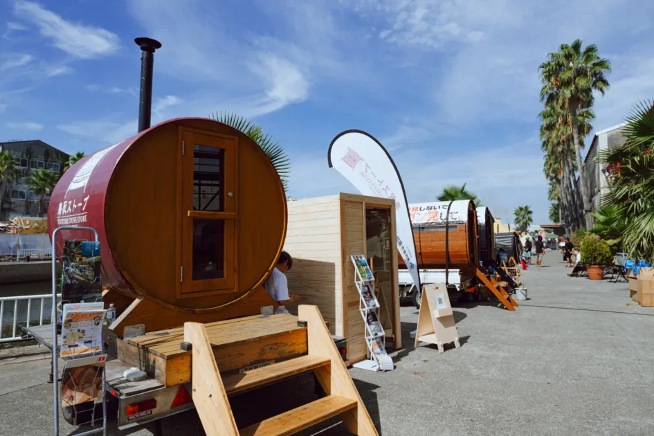 バレルサウナや木製小屋が展示された屋外イベント会場
