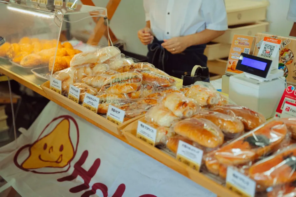 メロンパンや惣菜パンが並ぶパン屋のカウンター