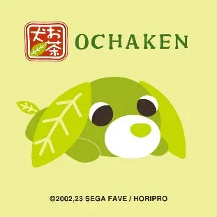 緑色の体が特徴的な人気キャラクター「お茶犬」が描かれたイラストです。お茶の葉をモチーフにした耳と尻尾を持つ犬が横たわっており、上部には「お茶」のロゴと「OCHAKEN」の文字が配置されています。