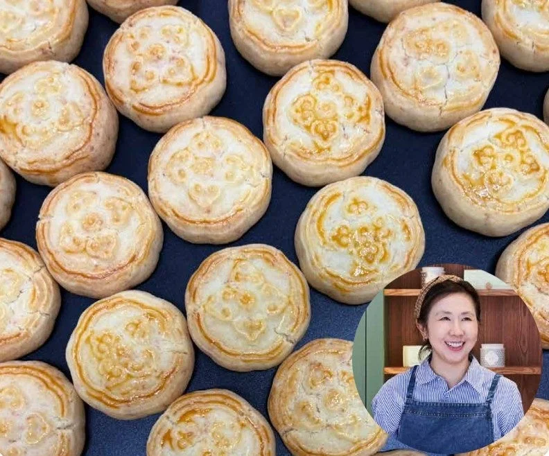 暗い背景に多数の丸い焼き菓子が並べられており、それぞれに美しい模様が施されている。