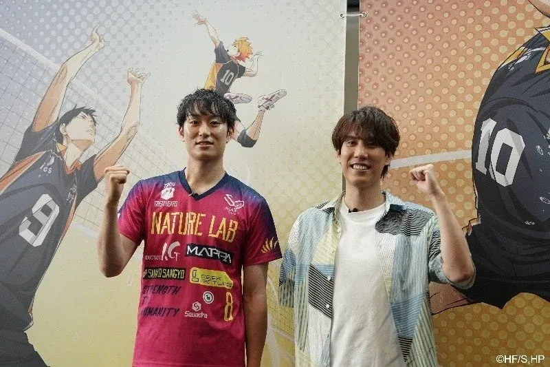 バレーボールアニメ『ハイキュー!!』のキャラクターを背景に、笑顔でガッツポーズをする2人の男性