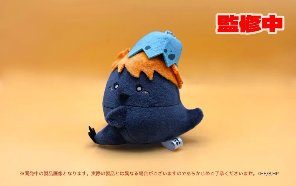 紺色の体にオレンジ色の髪、水色の帽子をかぶったキャラクターのぬいぐるみ