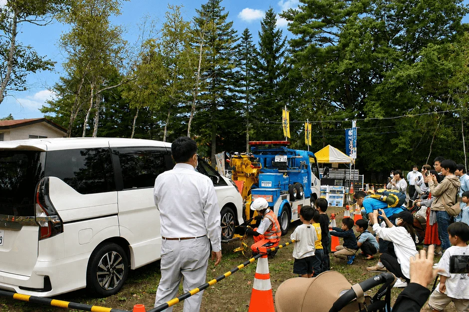 JAFのレッカー車がミニバンを牽引する様子を実演しています。