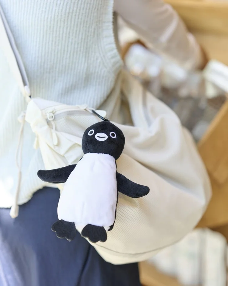 ペンギンのぬいぐるみポーチをバッグに付けている様子