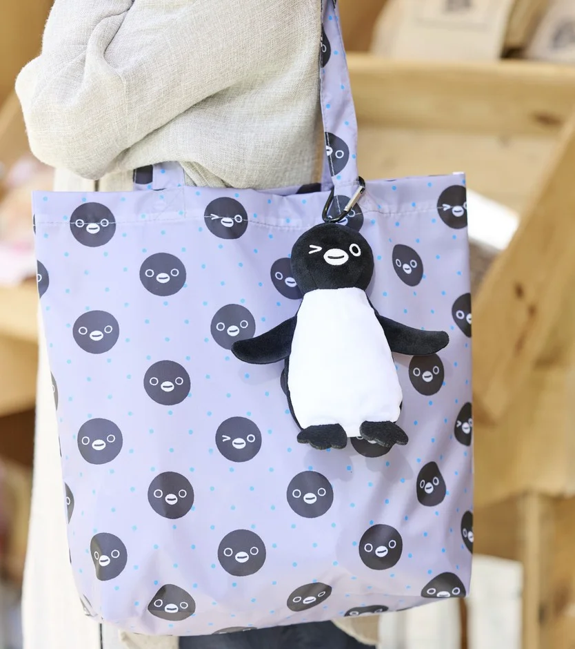 ウインクしたペンギンのぬいぐるみとグレーのエコバッグ