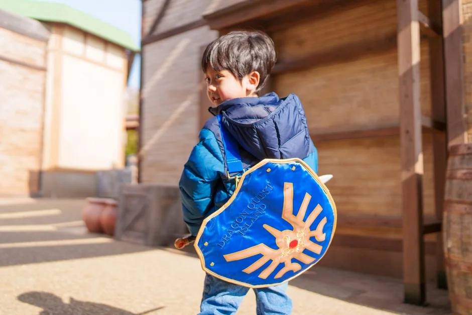 男の子がドラクエの盾と剣を身につけて楽しんでいる様子