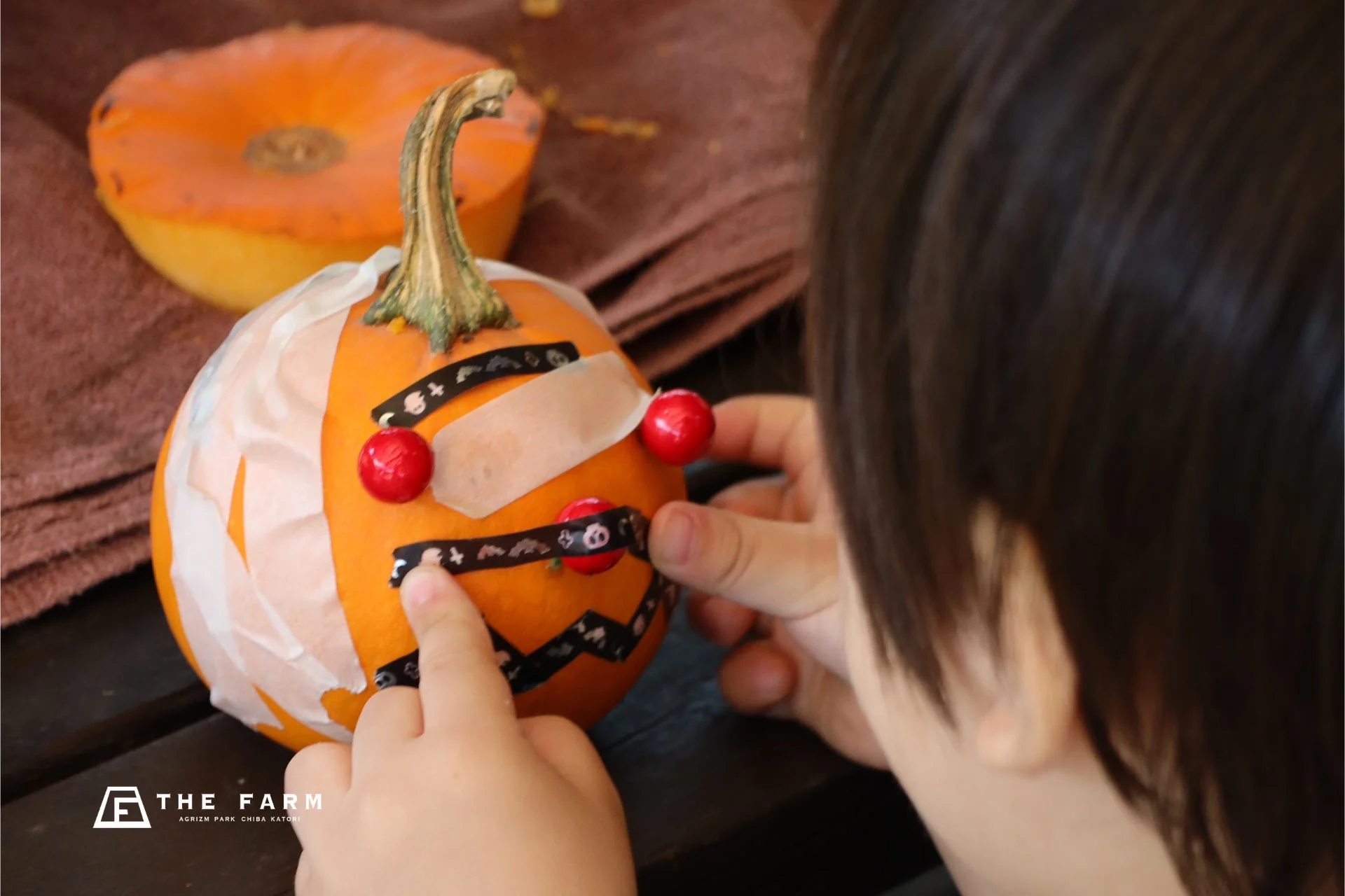 子供がカボチャを飾り付ける様子