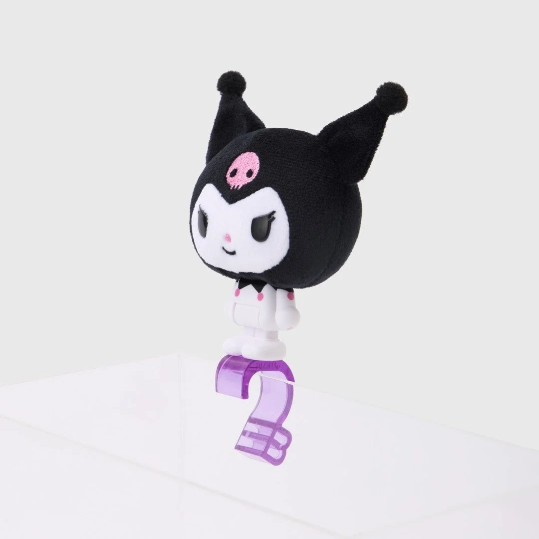 白い背景に、サンリオの人気キャラクター「クロミ」のぬいぐるみが立っています。クロミは紫色の数字の「2」の形をした台座に乗っており、可愛らしい表情をしています。